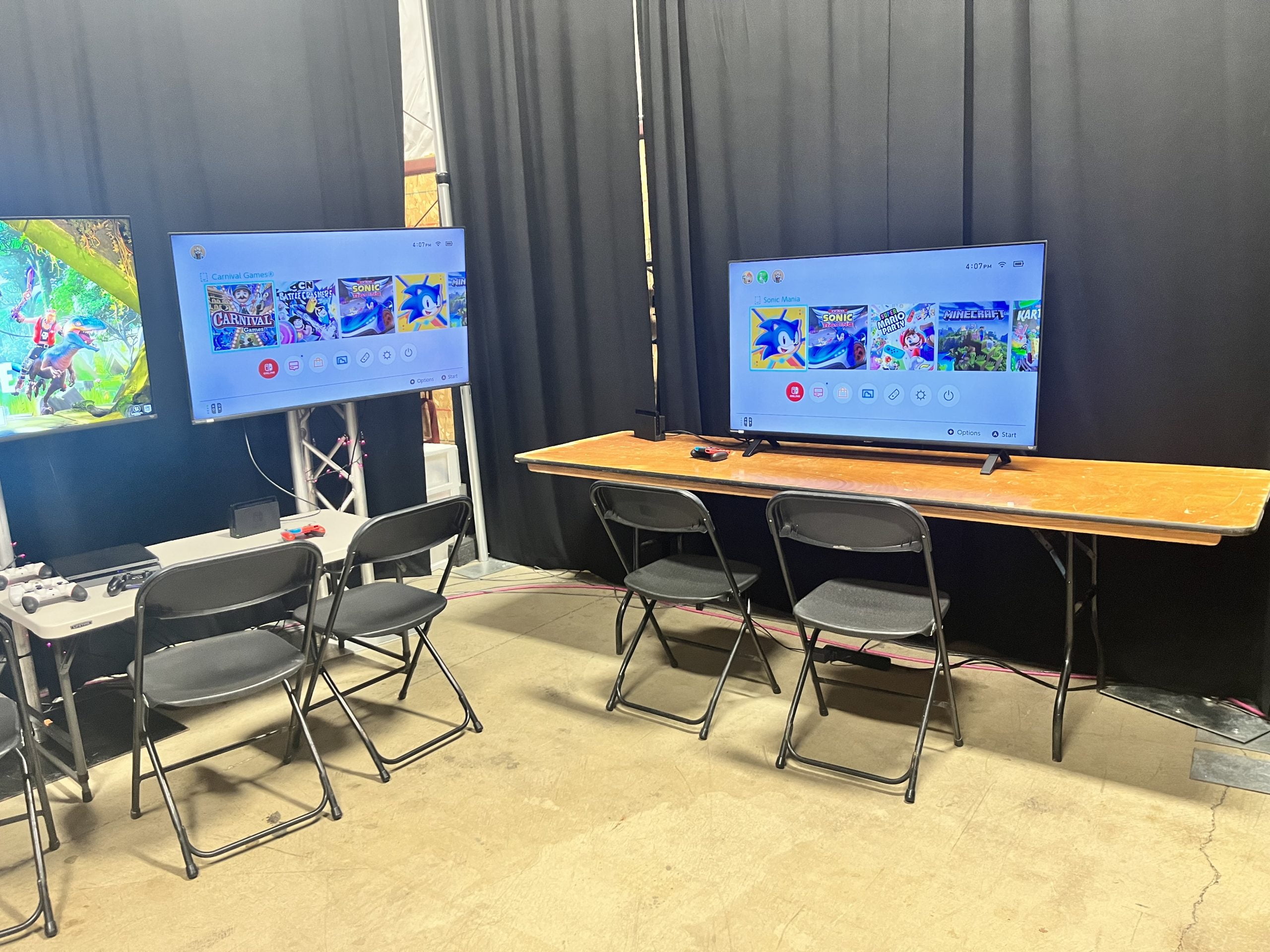 big screen TVs set up with PS 5 and Nintendo Switch consoles scaled