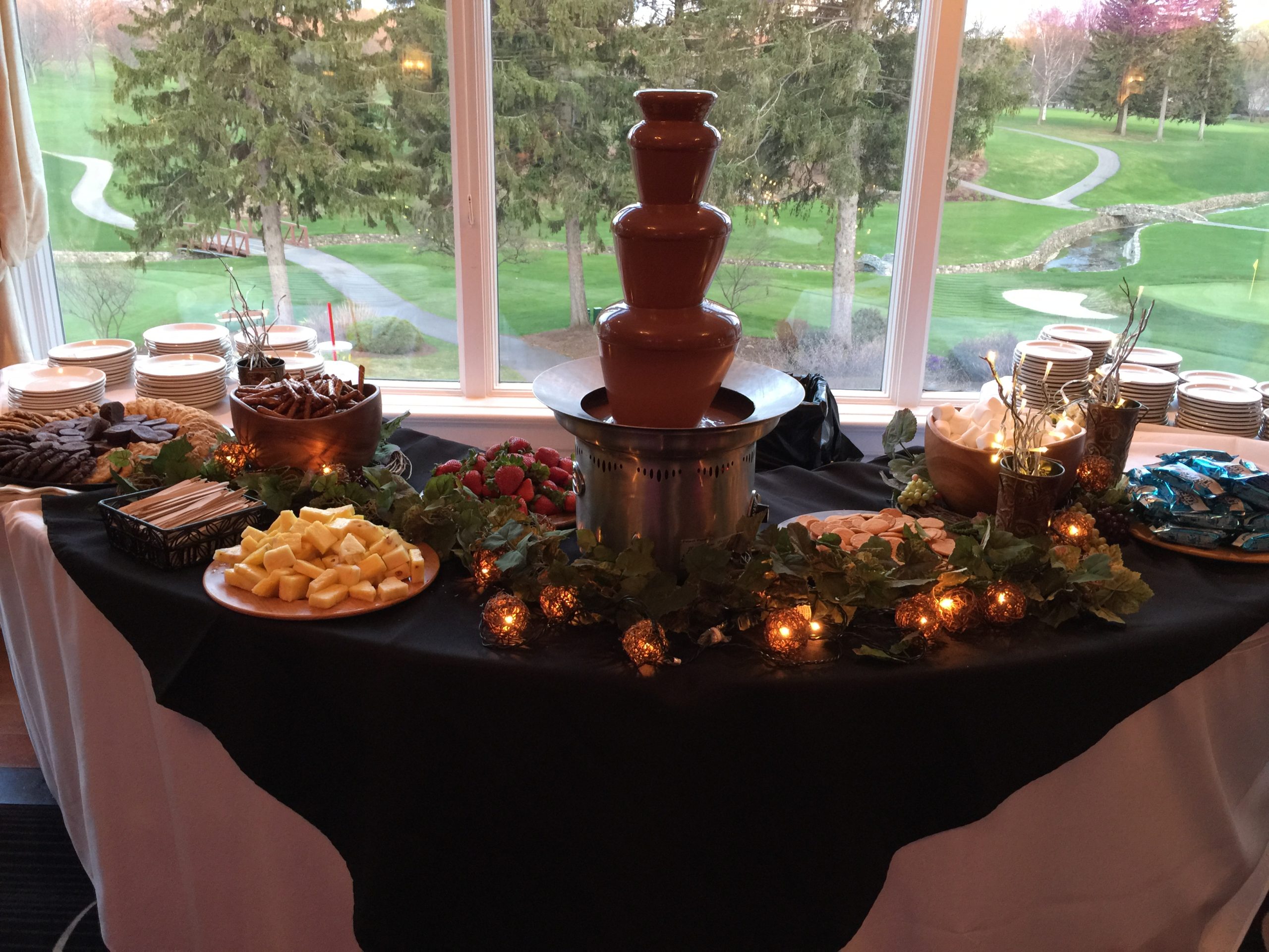 luscious chocolate fountain flowing with an outside view scaled
