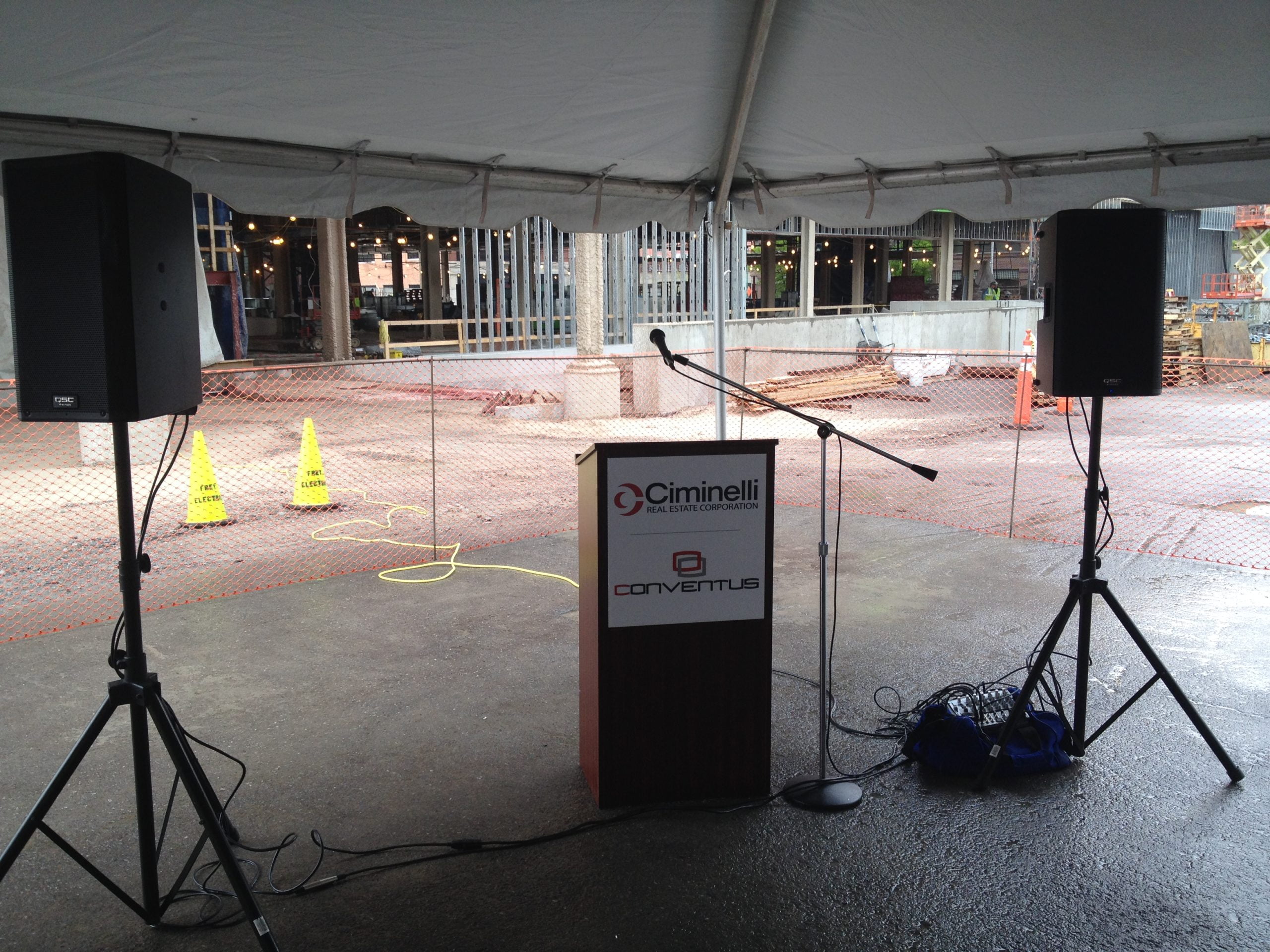 small sound system and podium under a tent scaled